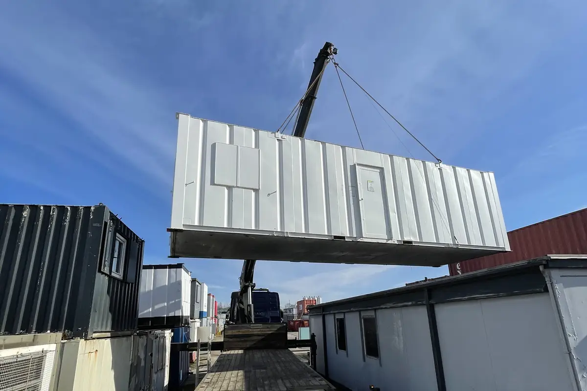 Portable building lifted clear of its base by our own HIAB