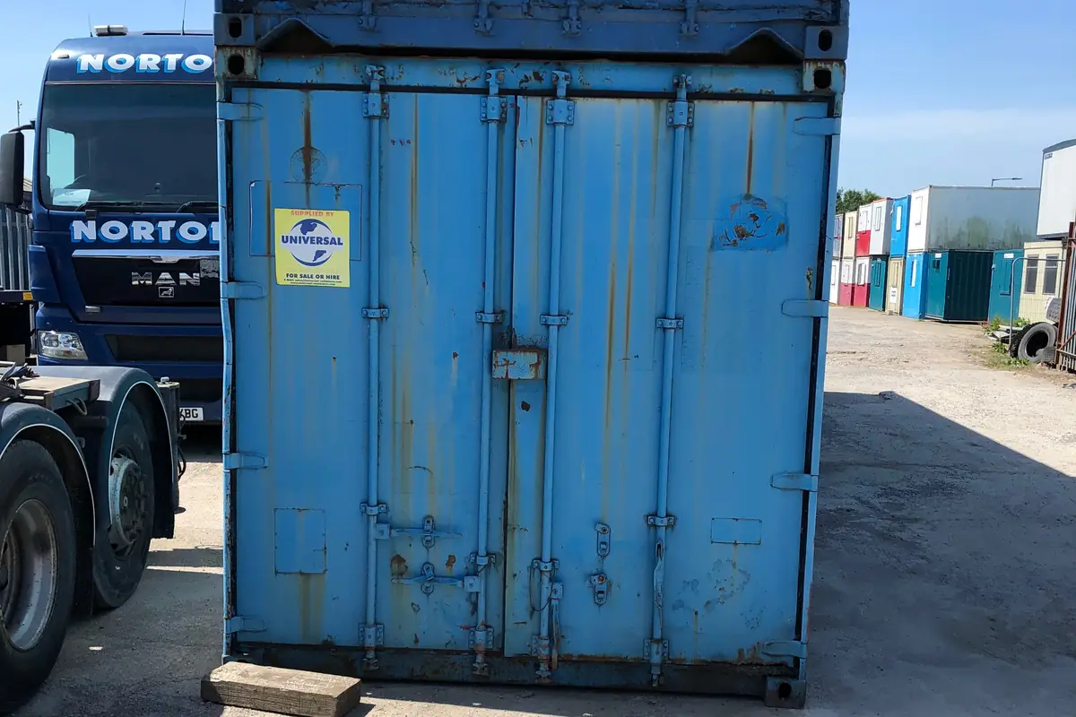Used storage container loaded onto a flatbed lorry for collection