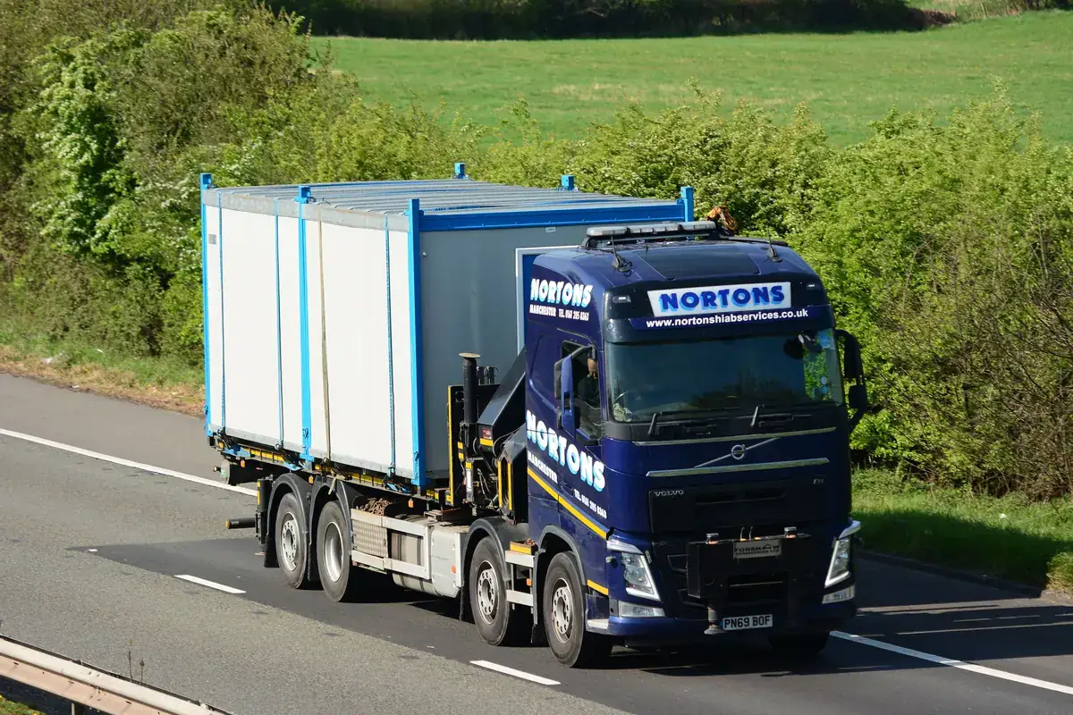 Modular bay on a flatbed lorry being delivered to a prepared site