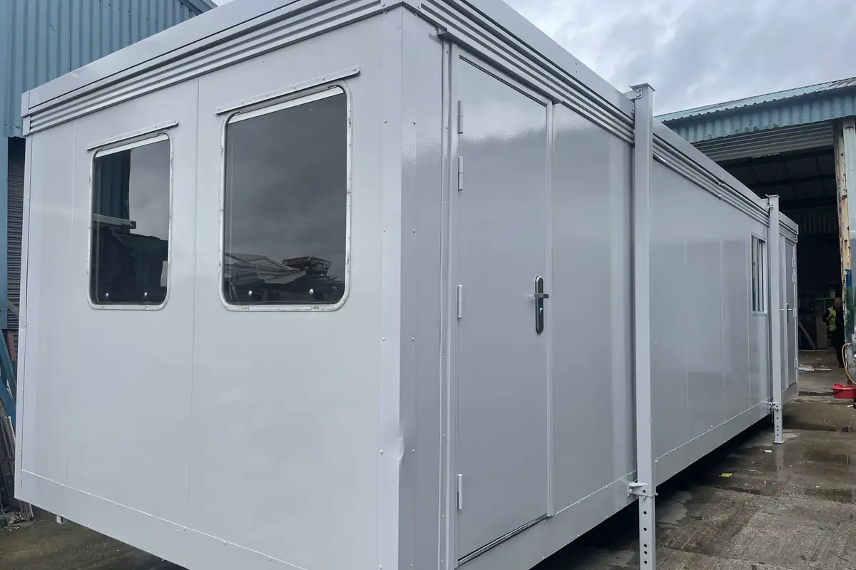 Used prefabricated classroom unit with large windows standing on a school site